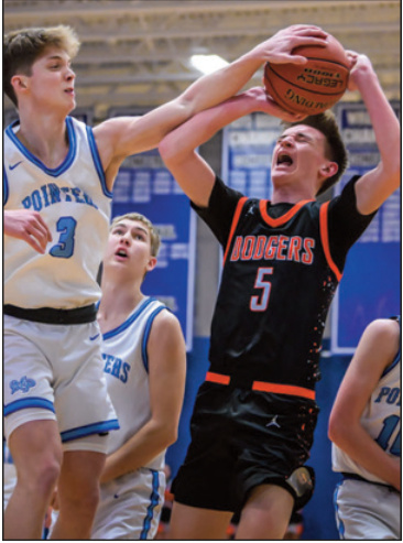 Brett Bossert blocks a shot by Dodger Griffin Busch. Photo by Bret Pe- terson.