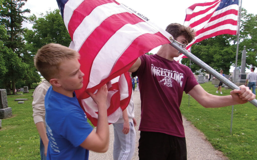 High school students are among the community members who help put up the Avenue of Flags.