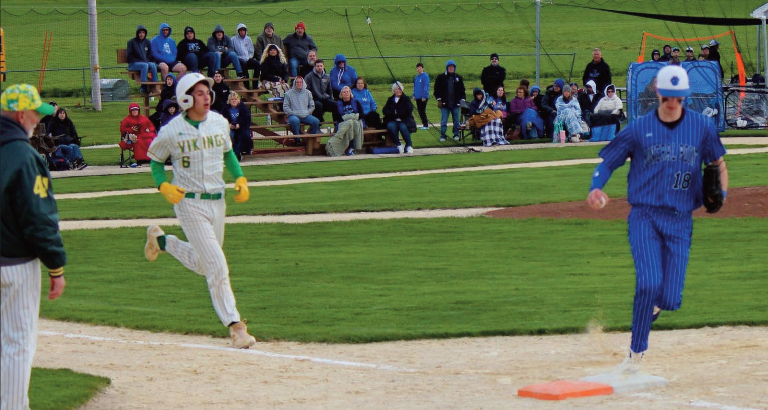 Fans at Field of Dreams watch Pointer pitcher Hudson Schroeder beat Pecatonica's Cooper Schraepfer at first for an out.