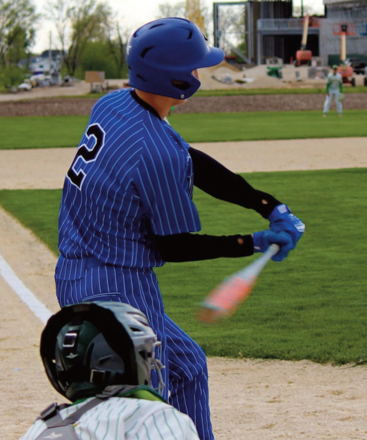 Pointer Cole Ripp about to take a cut on this pitch as in the background you can see the MLB Field of Dreams stadium being worked on left field.