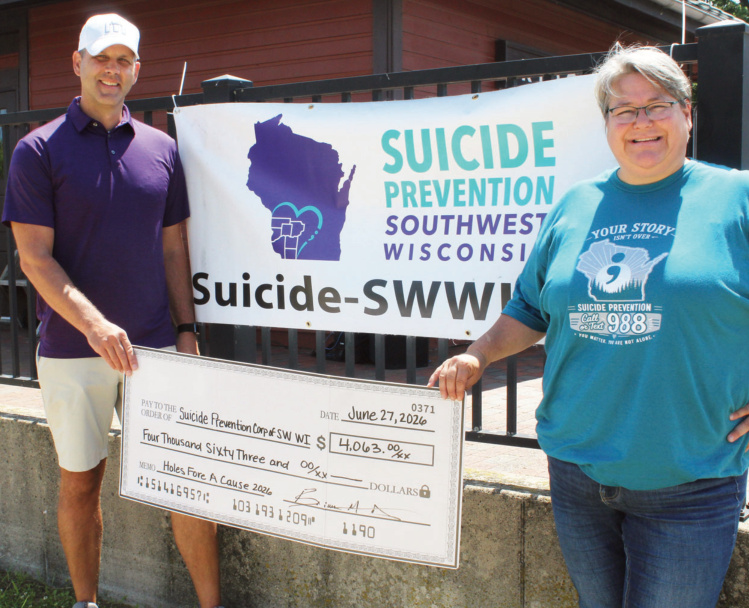Following the Suicide Prevention of Southwest Wisconsin Butterfly Release at the Ridgeway Independence Day celebration, Brian Arndt- one of the four golfers who participated in the "Holes Fore a Cause" event earlier this summer-presented Susan Springer with a check rep- resenting the funds he raised during the full day of golfing.