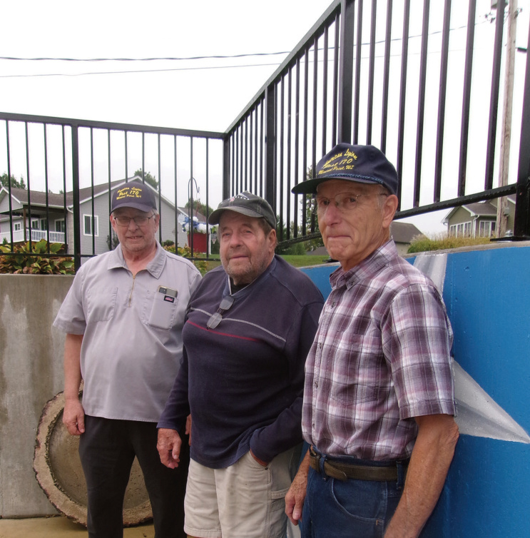 Mineral Point American Legion Commander Jim Wehrle, John Chris- tianson, who designed and built a railing for the Post's patio, and Legion member Jack Lawinger stand in outdoor gathering space near comple- tion at the Legion and VFW building.