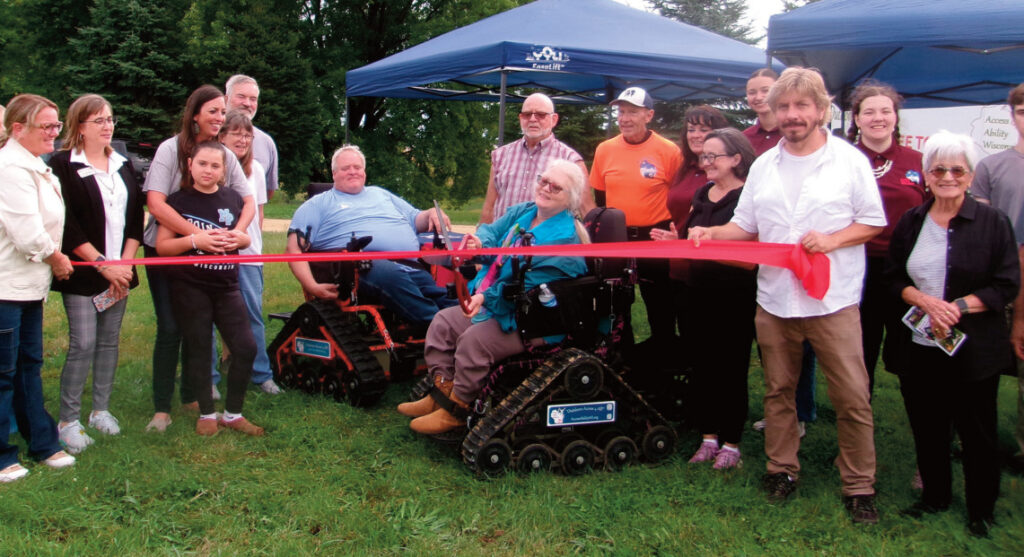 President and co-founder Monica Spaeni of Access Ability Wisconsin Outdoors Access 4 All cuts a ribbon at its new headquarters in Mineral Point Tuesday afternoon. It is a statewide non-profit that expands access to nature for people with mobility challenges. The education center will offer nature-based programs, includ- ing farm-to-table and field-to-table educational opportunities for all abilities and ages, as well as other pro- gramming. The group will host an Adventure Day Saturday from noon to 4 p.m. at Blackhawk Lake, Highland.
